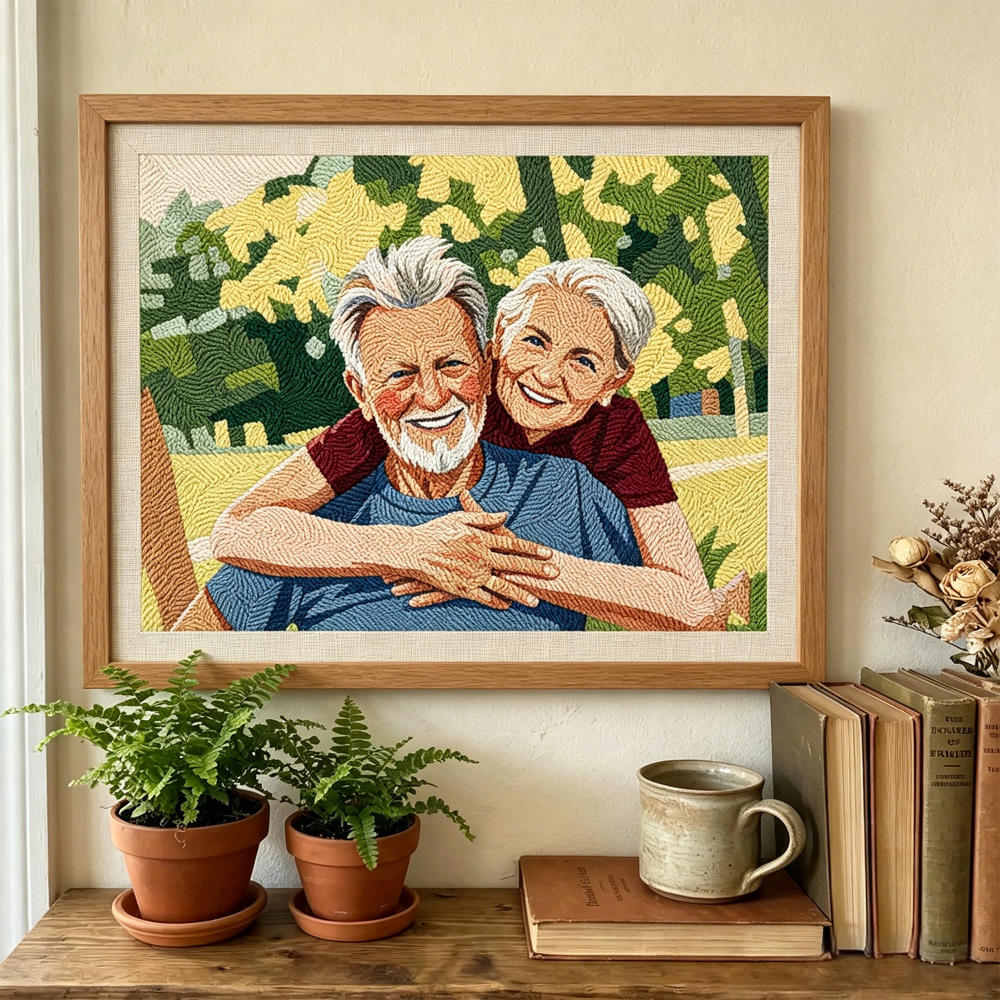 Framed embroidered portrait of an elderly couple on a shelf with plants and books.