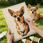 Person stitching a dog portrait on fabric with a real dog sitting in the grass.