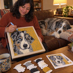 Dog on the couch next to its custom punch needle pet portrait